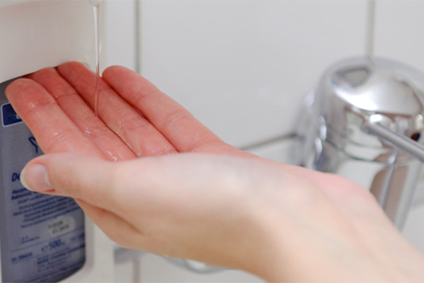 Bild von Hand unter Desinfektionsmittelspender